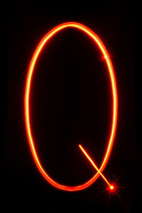 red light painting letter I on black background