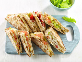 various sandwiches on wooden cutting board