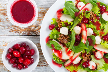 salad of apple, spinach, mini mozzarella balls, lettuce leaves,