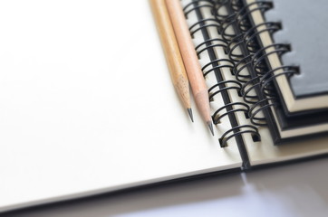 Selective focus of wooden pencils on blank sketched book with copy space for writing your new idea