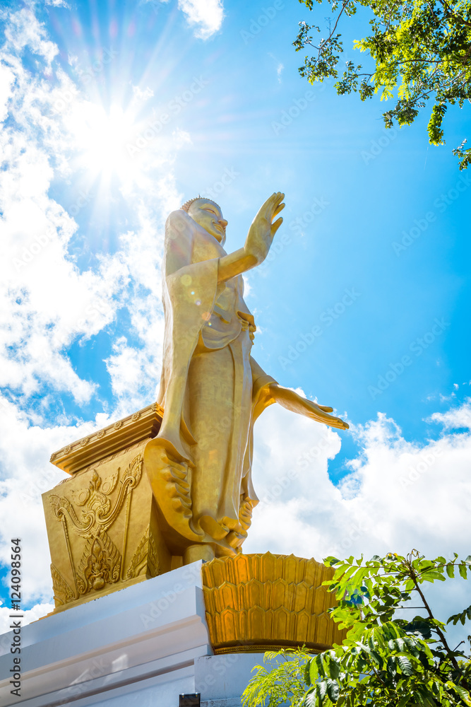 Wall mural Big standing buddha statue with sun