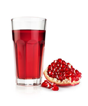 Pomegranate juice in a glass and a piece of pomegranate isolated