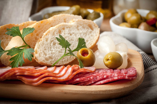 Tapas with sliced sausage, salami, olives, marinated onions, cuc