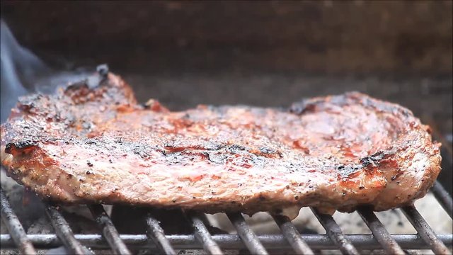 Bbq, juicy steak entrecote on grill, time lapse
