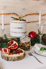A cozy new year atmosphere made of cones nuts and tempting pomegranate, white and green composition