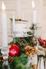 Christmas composition of wood, white candles and red fruit, cozy atmosphere