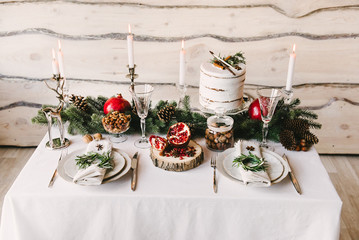 Picture of a small table served for two decorated for the christmas with a contrast of green white and red colors