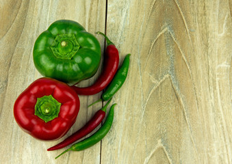 Sweet and chili peppers on wooden background