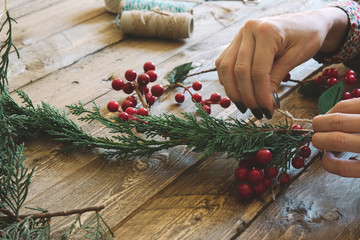 Florist at work: Creating a wooden wreath with christmas  red ba