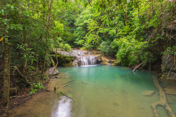 Emerald waterfall in forest landscape.