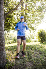 junger mann läuft durch bach im wald
