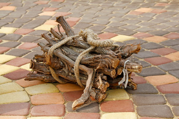 Firewood bundle tied with a rope closeup on the pavement