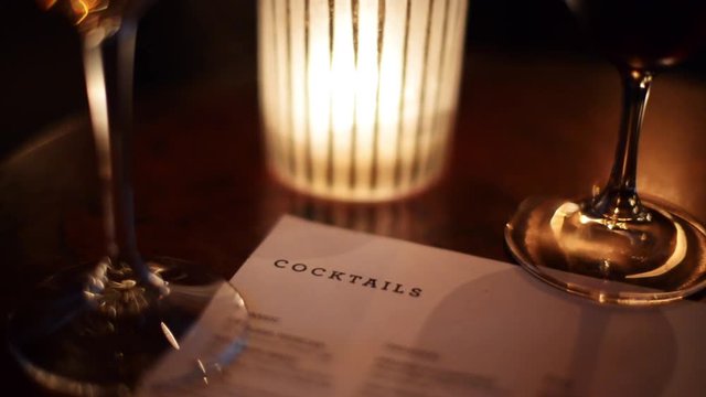 Cocktail menu with glasses, romantic candle light, close up