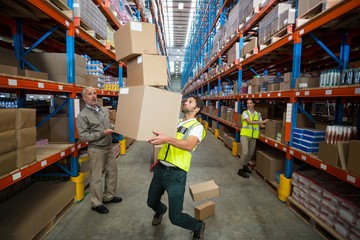 Worker losing his balance while carrying cardboard boxes