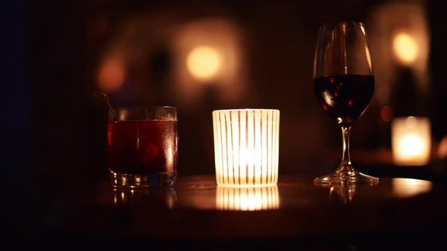 Drinks near candlelight, alcoholic beverages, close up, romantic date night.