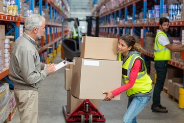 Warehouse manager noting on clipboard 