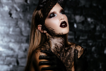 Beautiful girl with long dark hair and black hands in the form of a dark queen of Halloween....