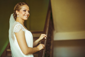 young bride sitting on stairs and posing for the camera