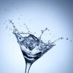 Water splash in glass with ice cubes