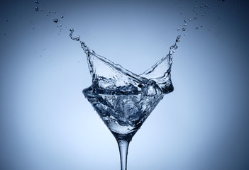 Water splash in glass with ice cubes