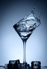 Water splash in glass with ice cubes