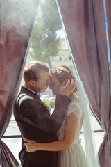 Obraz premium happy couple hugging on the background of window
