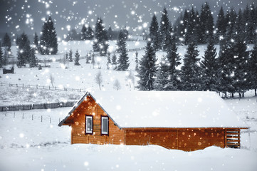 Mountain hut in winter with snowflakes. Christmas concept