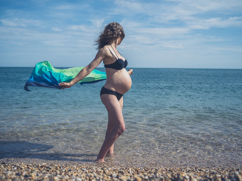 Pregnant woman with sarong on the beach