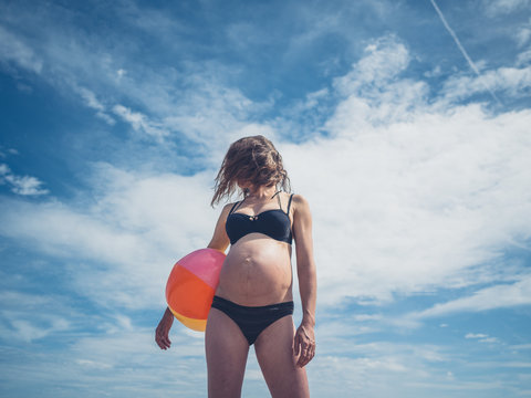 Young pregnant woman with beach ball