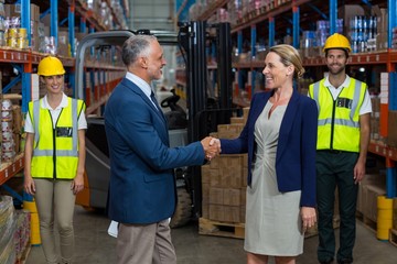 Warehouse manager shaking hands with client