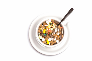 Medical capsules and tablets inside coffee cup