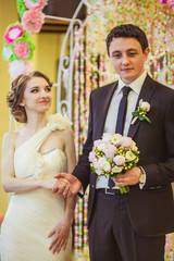 Bride admires tall groom while he holds her hand during the cere