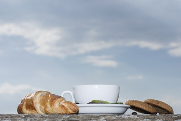 Cup of coffee or tea with croissant