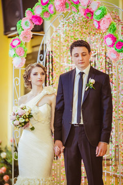Thoughtful wedding coupel holds each other hands tightly while s