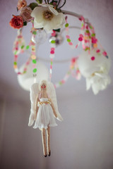 Figure of a bride hangs from  the lamp with pink garlands