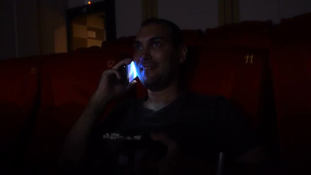 Man talking on the phone in cinema