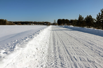 Fototapeta na wymiar Road in snow in cold winter day