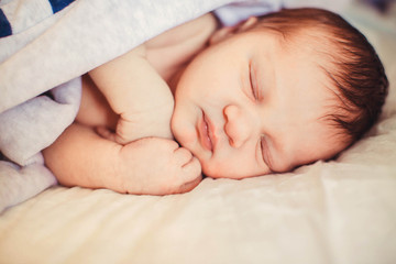 Incredible and sweet newborn baby sleeps on the bed