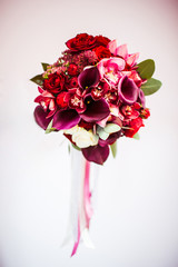 Beautiful dark wedding bouquet stands on the white background