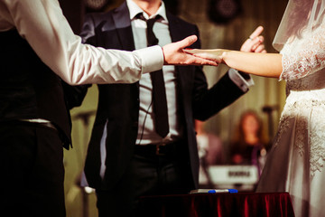 Bride and goom hold their hands together standing in the front o