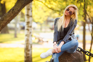 Fototapeta na wymiar Beautiful blonde girl with glasses and leather jacket, fashion outdoor photo 