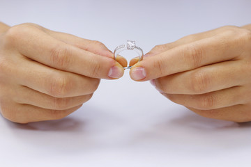 Hands holding a ring on a white background