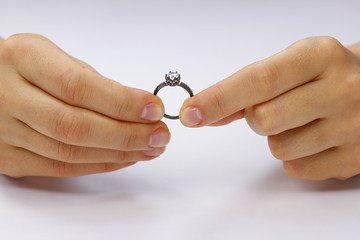 Hands holding a ring on a white background