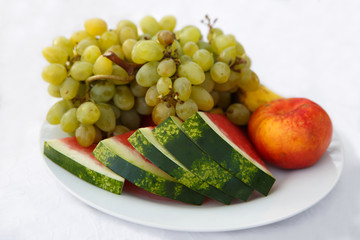 Mixed fruit: watermelon, apple and grapes in a dish isolated. Food is healthy vegetarian.
