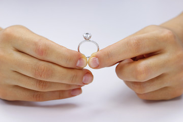Hands holding a ring on a white background