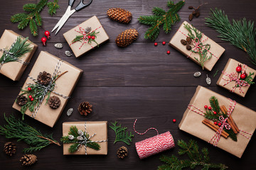 Gift or present box wrapped in kraft paper with christmas decoration on rustic wooden background...