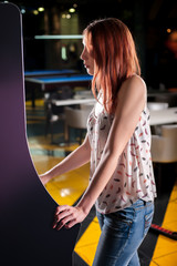Young woman playing arcade