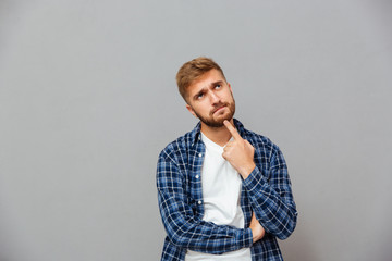 Portrait of a pensive man touching his beard with hand