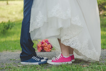 Bride and groom legs with wedding bouquet