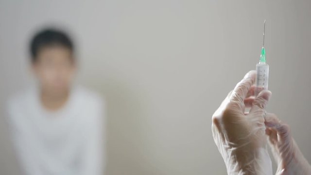 Cute little boy afraid of injection. nurse prepares a syringe